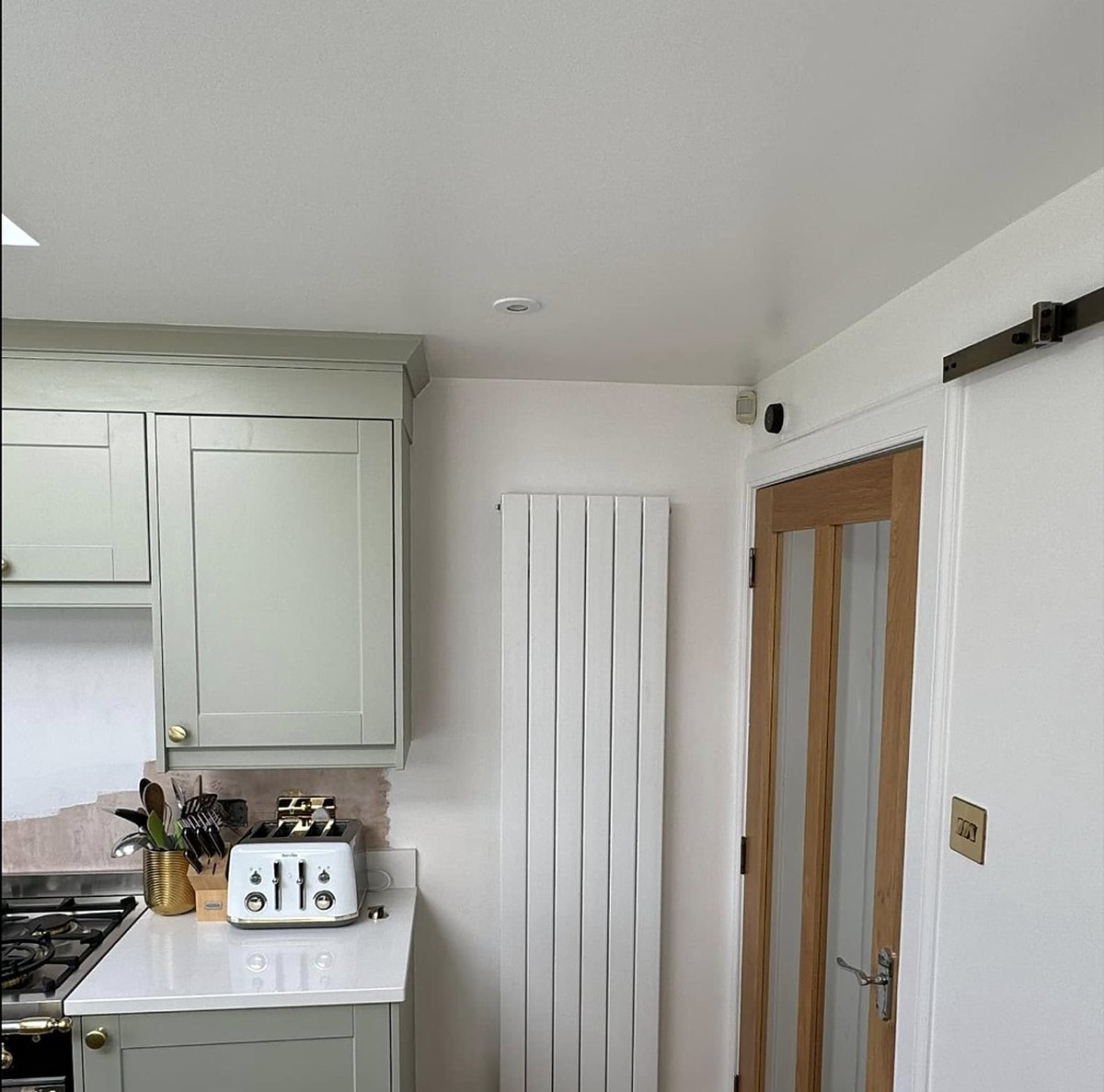 Vertical designer radiator fitted in a kitchen by Heattech Gas Services