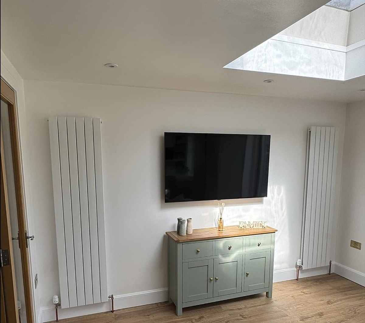 Two vertical radiators installed in a living room by Heattech Gas Services
